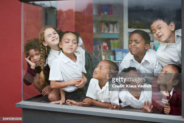 school children pressing their faces against the window in the library - naughty kids in classroom stock pictures, royalty-free photos & images