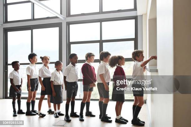 school children queuing for lunch in the canteen - private school uniform stock pictures, royalty-free photos & images