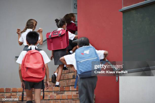 school children running on staircase to school building - enfant cartable photos et images de collection