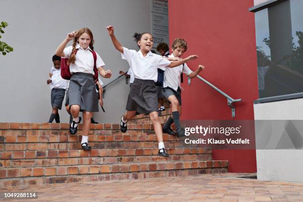 school children running and jumping off staircase from school building - child running up stairs stock pictures, royalty-free photos & images