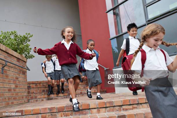 school children running and jumping off staircase from school building - independent-school-education stock pictures, royalty-free photos & images