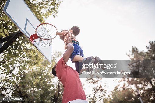 Far och son att ha kul, spela basket utomhus Far och son att ha kul, spela basket utomhus