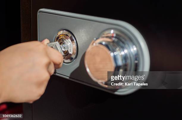 close up of human hand opening a safe deposit box - kluisdeur stockfoto's en -beelden