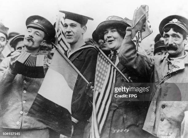 Sailor, a French soldier and a red cross worker celebrate the signing of the Armistice ending World War I, Paris, France, November 11, 1918.