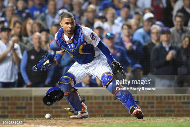 Willson Contreras of the Chicago Cubs checks a runer after a wild pitch during the National League Wild Card game against the Colorado Rockies at...