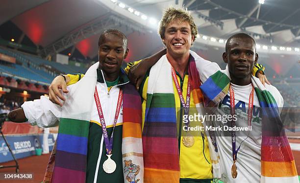 Simon Patmore of Australia poses for a photograph with his gold medal after winning the men's T46 100 metres final next to silver medallist Samkelo...