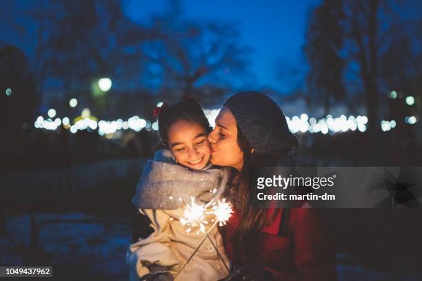 mamma kysser dotter på julnatten - sparkler bildbanksfoton och bilder