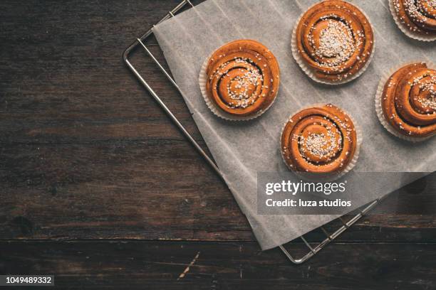 traditional swedish cinnamon bun on a oven rack - papel de cera imagens e fotografias de stock