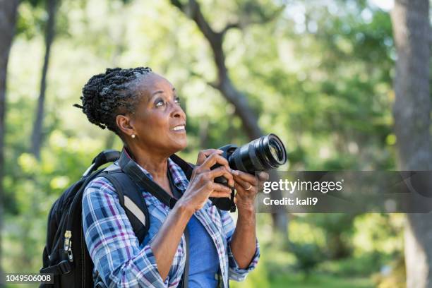 senior afroamerikanerin wandern, mit kamera - african american hiking stock-fotos und bilder