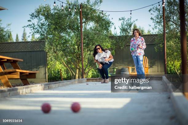 two women drinking wine and playing bocce - bocce ball stock pictures, royalty-free photos & images