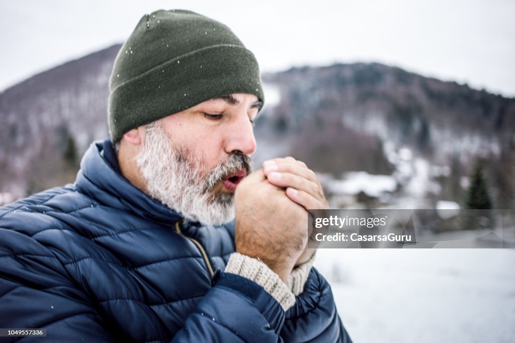 Uomo maturo all'aperto nella natura in una fredda giornata invernale
