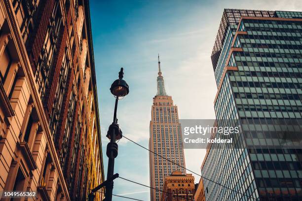skyline of midtown manhattan with distant view of empire state building - broadway street stock pictures, royalty-free photos & images