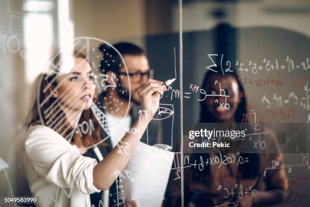 writing mathematical formulas on transparent wipe board - quadro transparente imagens e fotografias de stock