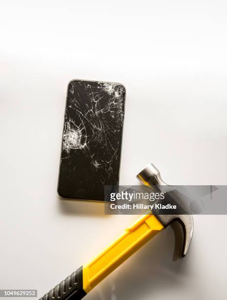 broken phone with hammer - broken cell phone stock-fotos und bilder
