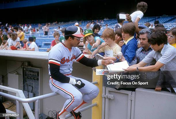 Outfielder Reggie Jackson of the Baltimore Orioles signs autographs for some fans prior to the start of a Major League Baseball game circa 1976....