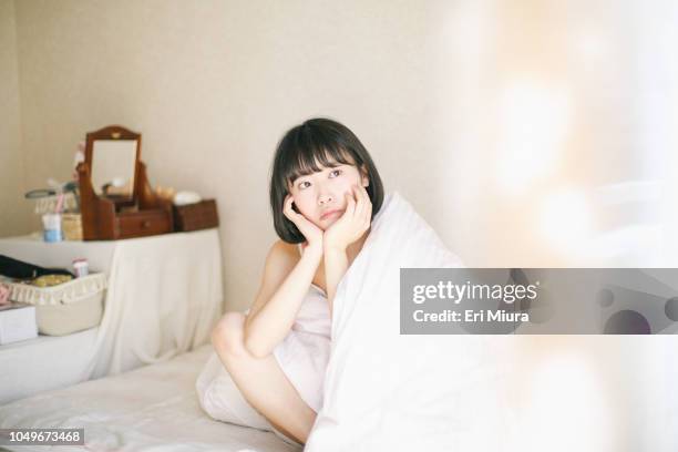 a woman thinking on a bed - bachelorette photos et images de collection