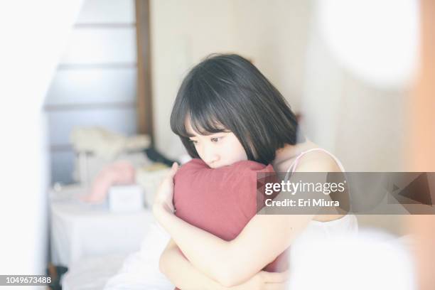 a woman thinking on a bed - 悩む　女性 ストックフォトと画像