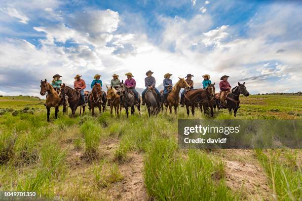 backlit line up of a group of cowboys and cowgirls - great american group stock pictures, royalty-free photos & images