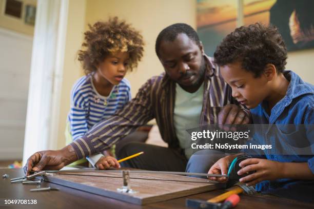 kids assisting their father repairing the shelf - fathers day tools stock pictures, royalty-free photos & images