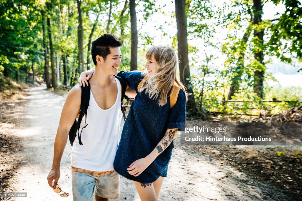 Couple Embracing On Way To Lake Together