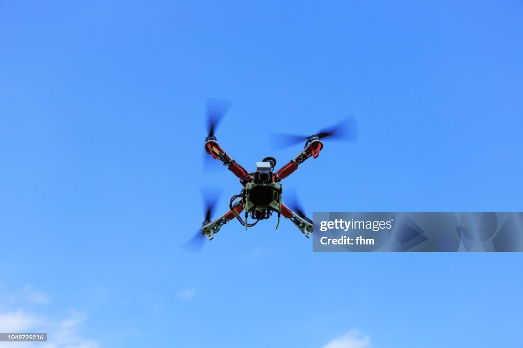 Flying quadrocopter/ drone in the sky - UAV unmanned aerial vehicle