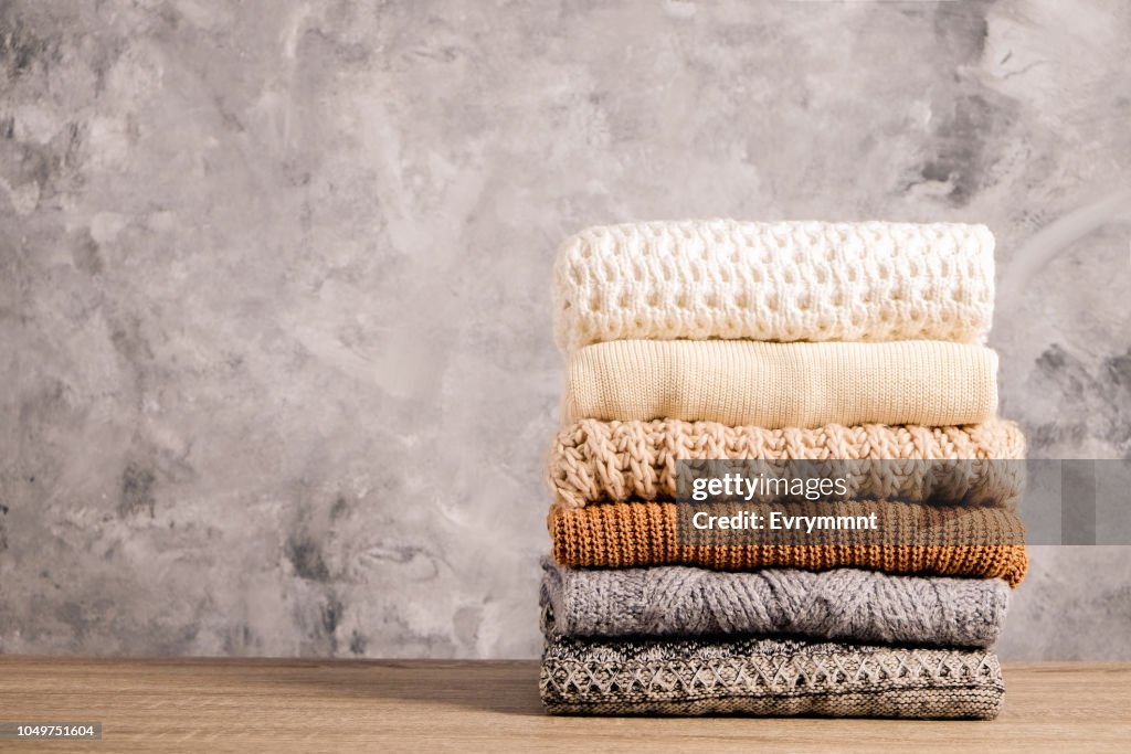Minimalistic rustic composition with stacked vintage knitted easy chic oversized style sweaters, knitwear outfit.