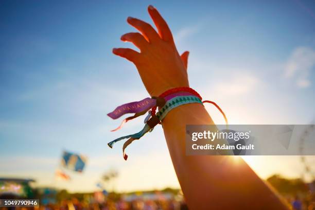 music festival hand waving - bracelet festival stock-fotos und bilder
