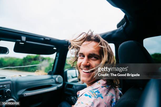 man riding in passenger seat of convertible - haare mann stock-fotos und bilder