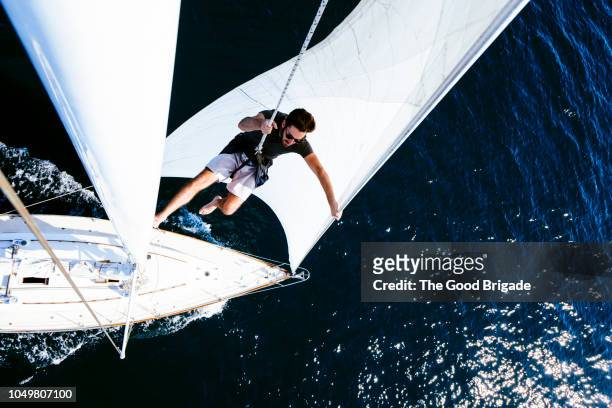man on sailboat wearing safety harness - dramatic millennials stock pictures, royalty-free photos & images