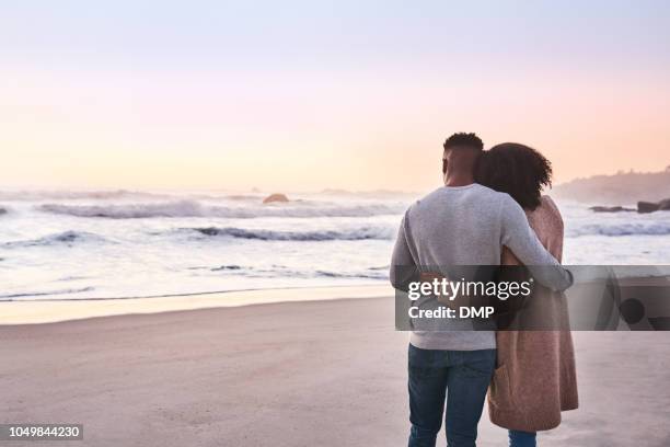 solnedgången tycks närmare på stranden - romantic couple back bildbanksfoton och bilder