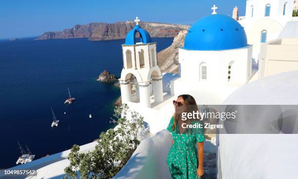 young woman standing by church on mountain against clear blue sky during sunny day - greece stock pictures, royalty-free photos & images