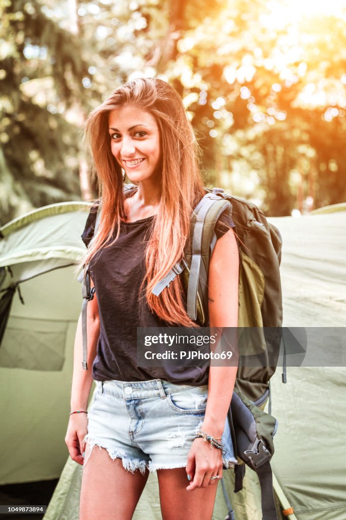 Portrait of young woman with backpack at camping