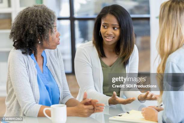 adolescente e a mãe dela falam durante uma sessão de aconselhamento - diferença entre gerações - fotografias e filmes do acervo