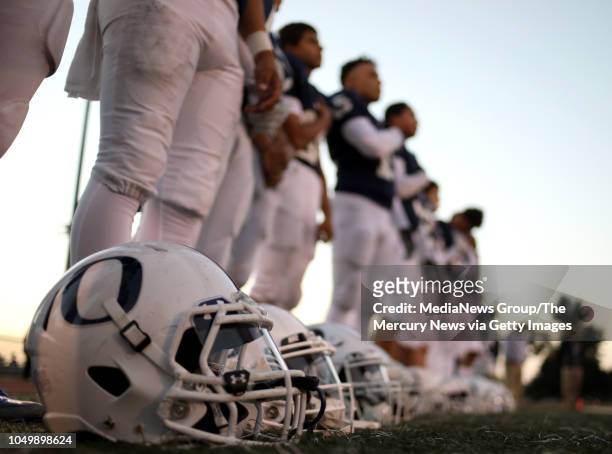 Overfelt High School football players stand during the playing of the National Anthem before the team's game against Gunderson in San Jose, Calif.,...