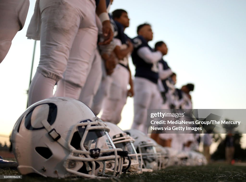 Overfelt High School football players stand during the playing of the