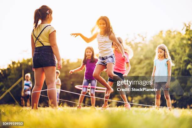 mädchen spielen zusammen bei sonnenuntergang - gummiband stock-fotos und bilder