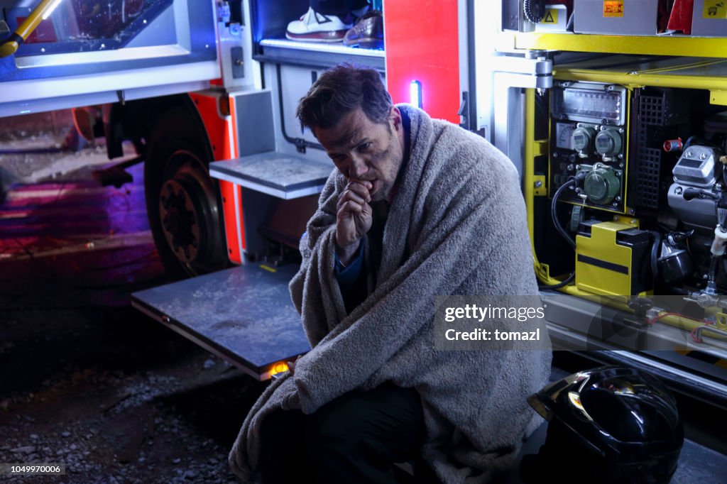 Big fire victim sitting on a firefighter's truck