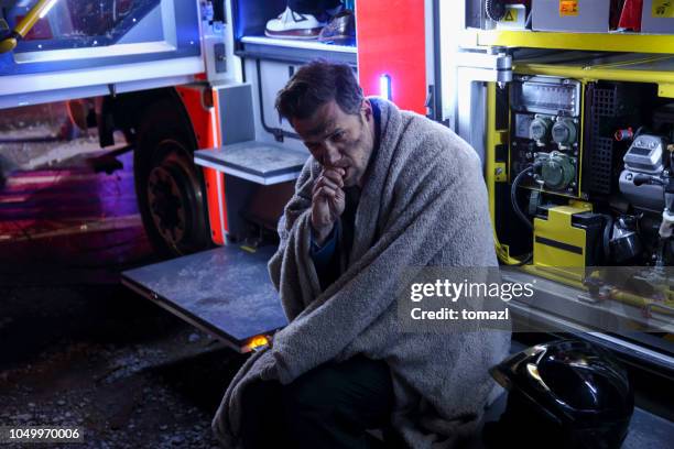 big fire victim sitting on a firefighter's truck - victim advocacy stock pictures, royalty-free photos & images