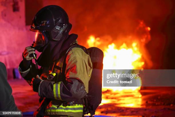 brandweerman zijn gasmasker voorbereiden alvorens in brand - brandweeruniform stockfoto's en -beelden