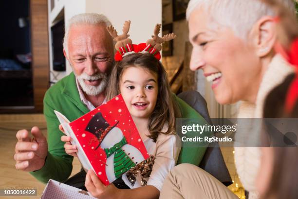 happy family reading christmas card - man reading card stock pictures, royalty-free photos & images