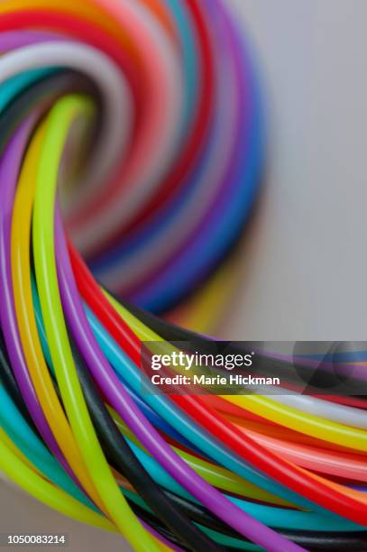 multi-colored strings of plastic tied in a knot in the upper left background. - biodegradable plastic stock pictures, royalty-free photos & images