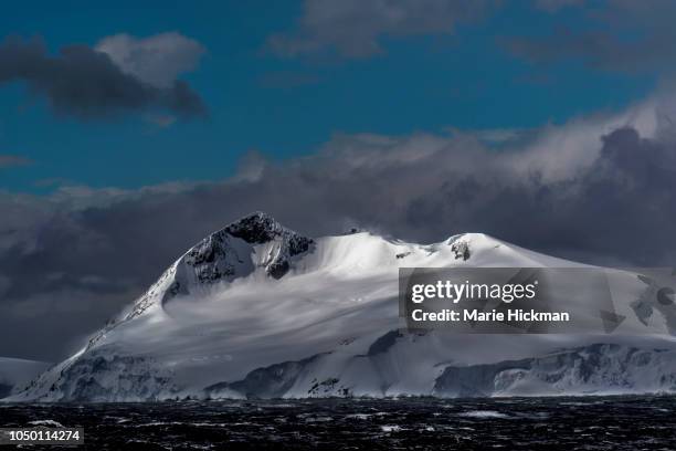 spot light on snow-capped mountain peak in antarctica. - antarctic peninsula stock-fotos und bilder