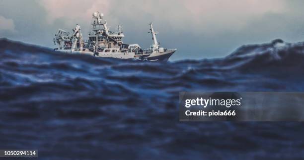 boot trawler zeilen vissen uit op ruwe zee - fishing boat stockfoto's en -beelden