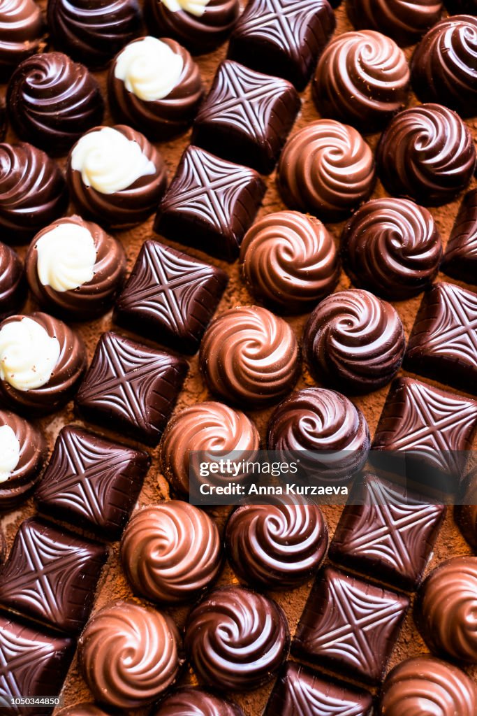 Premium collection of dark, milk and white chocolate sweets, selective focus. Chocolate background. Macro food photography. Collection of candies.