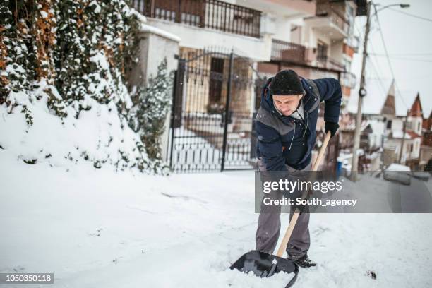 cleaning snow on the street - snow shovel man stock pictures, royalty-free photos & images