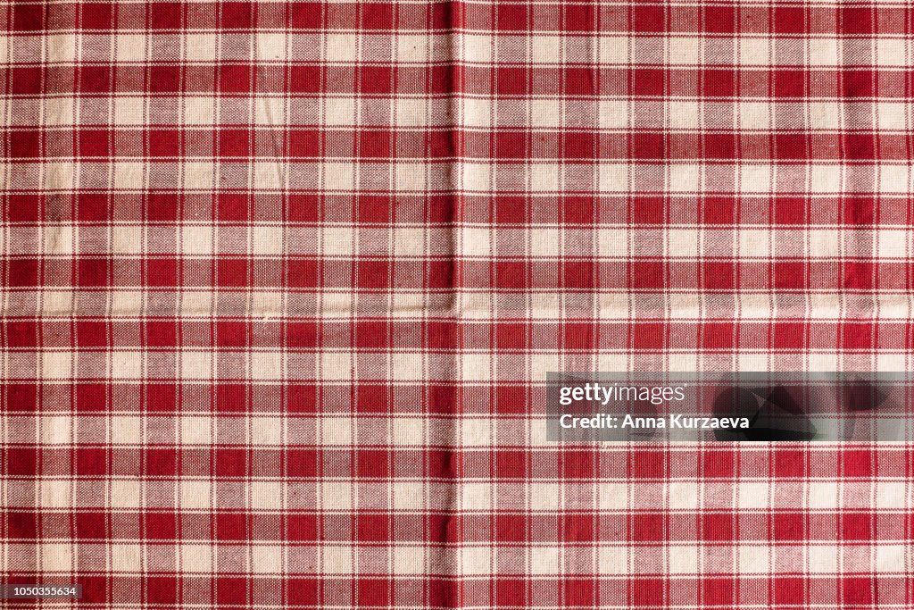 Textile background with a checkered red napkin, top view. Natural textile background. Fabric texture background. Texture of natural linen fabric.