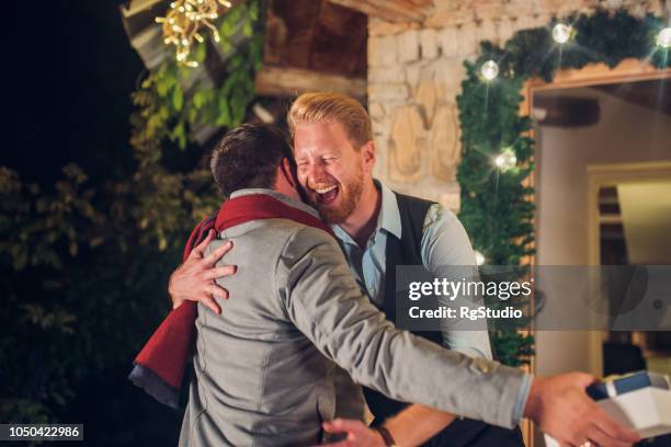 young men hugging - returning gift stock pictures, royalty-free photos & images