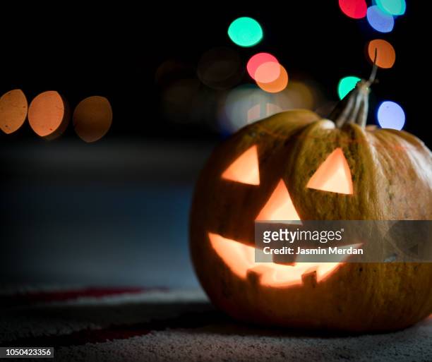 halloween pumpkin with blurred street lights - ugly wallpaper stock pictures, royalty-free photos & images