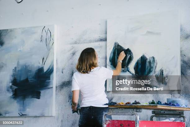 vrouw schilderij canvas in art studio - kunstatelier stockfoto's en -beelden