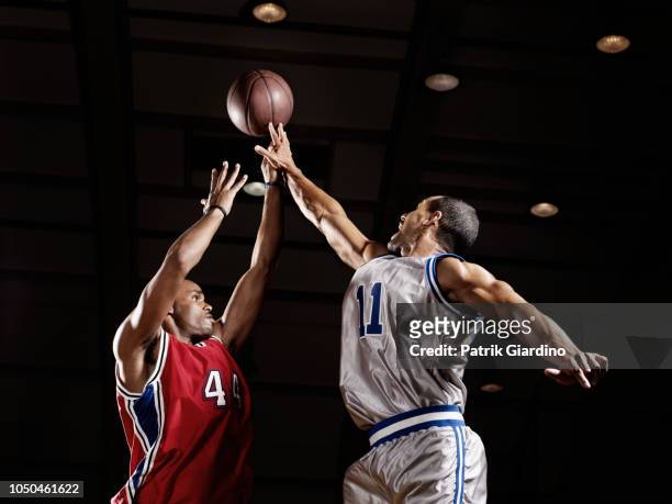 basketball player trying to take basketball from opponent - basketball stock-fotos und bilder